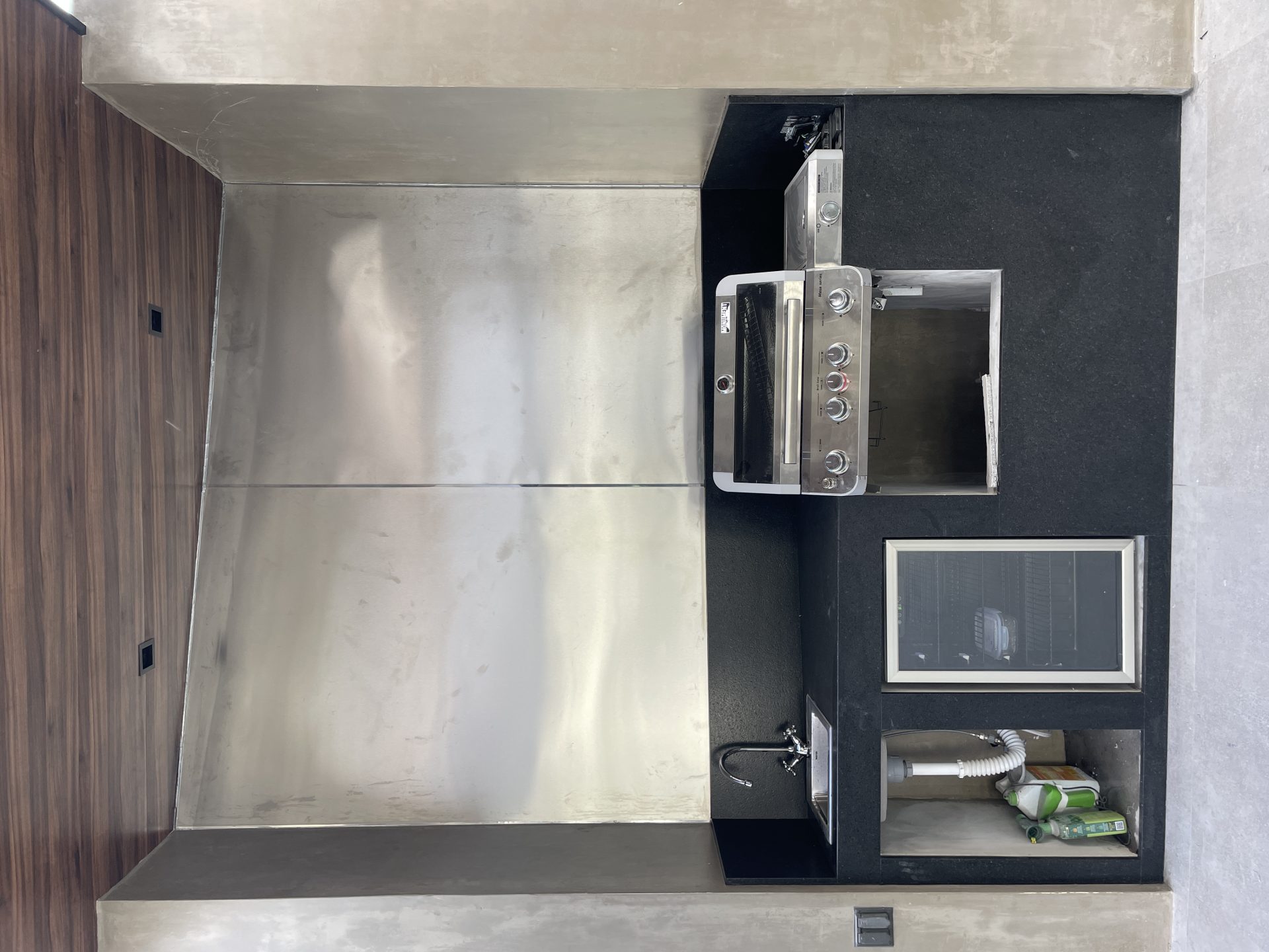 Molstone — Cocina exterior con tarja de acero inoxidable, gabinetes de nogal y cuarzo oscuro