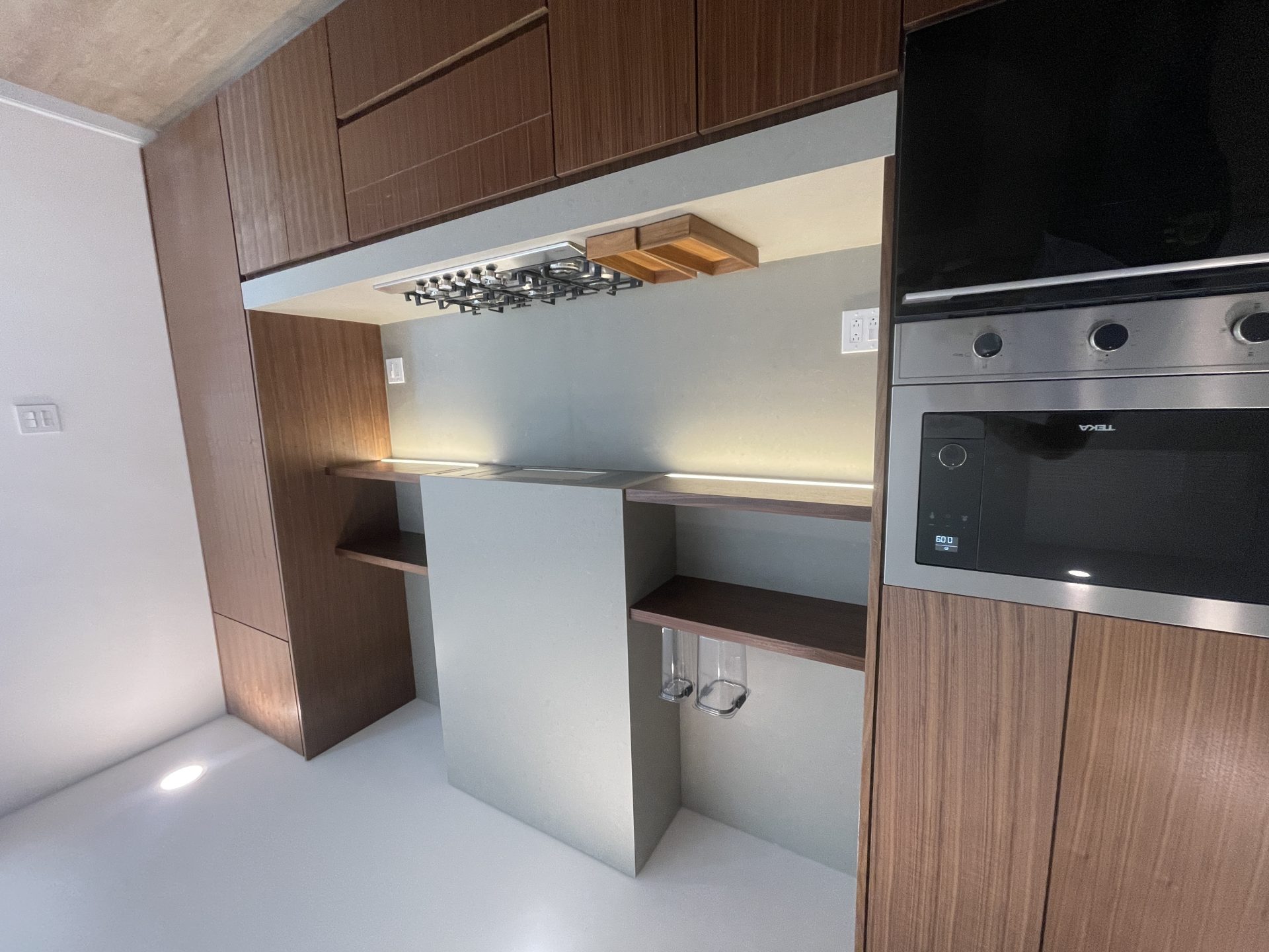 Molstone — Área de bar con copas, gabinetes de nogal rift y horno Teka empotrado