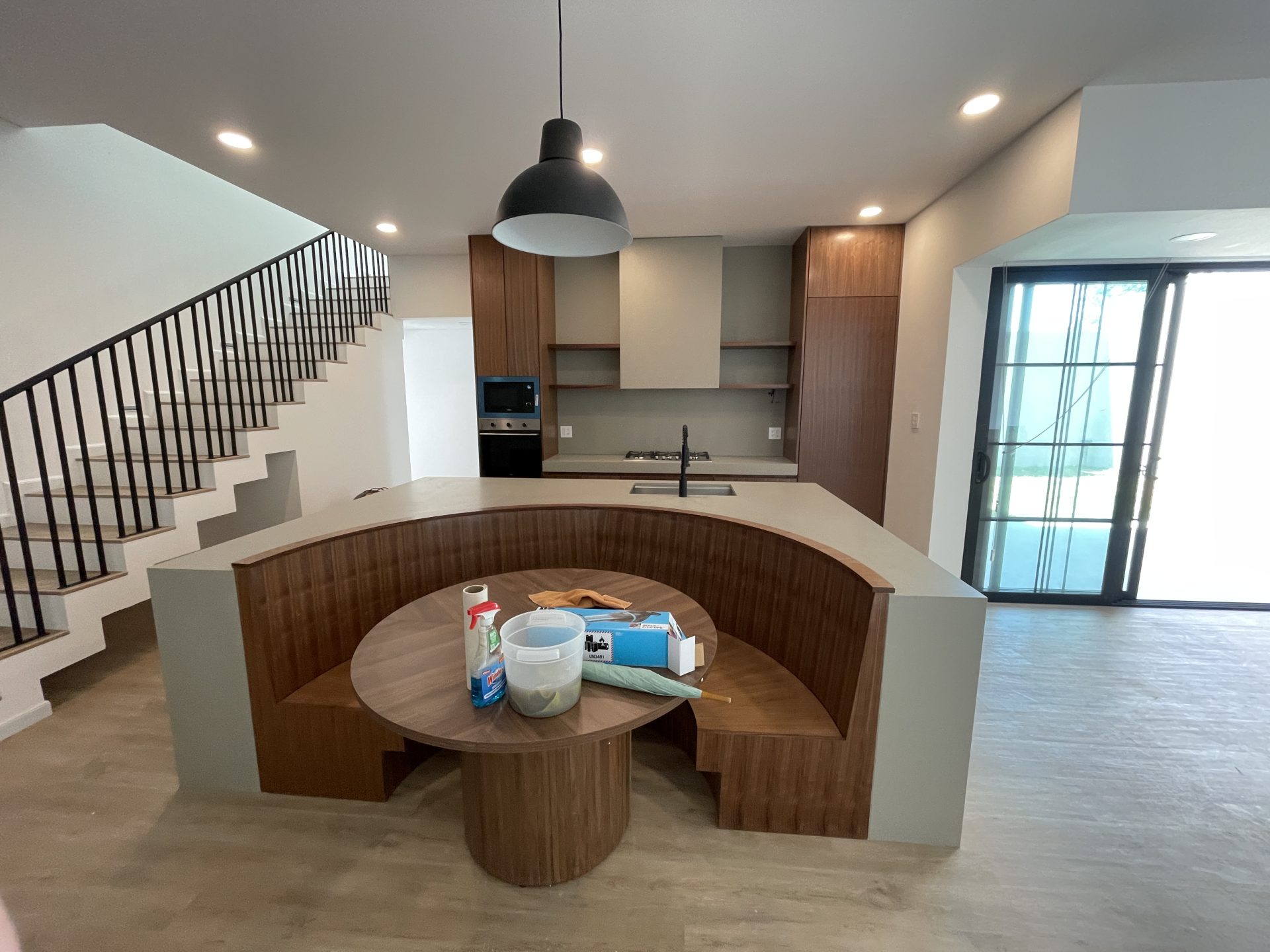Molstone Cocinas — isla circular en chapa de nogal rift y cuarzo Jura Beige con campana revestida